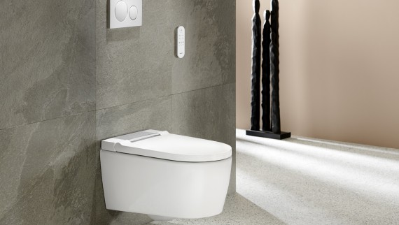 浴室配备白色 Geberit AquaClean Sela 智能坐便器和 Geberit Sigma20 冲水面板